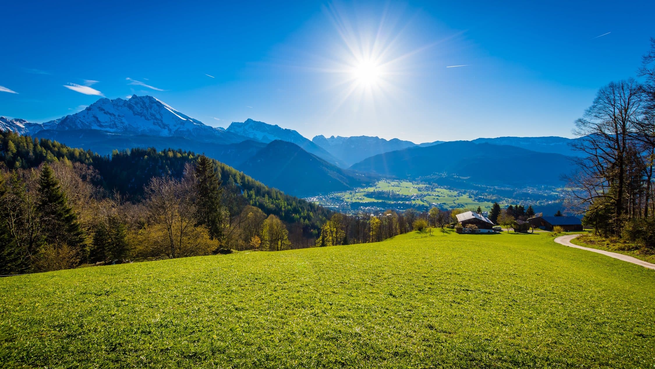 Berchtesgadener Land mit Bergen und blauem Himmel.